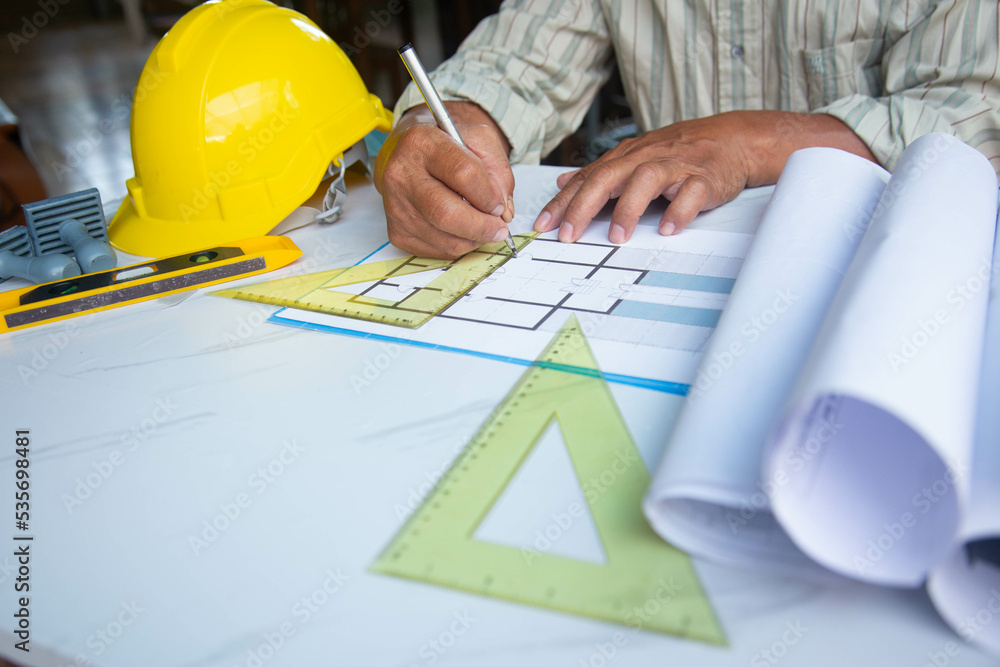 Architect designing project at Construction Site with blueprint Architect designing project at Construction Site with blueprint