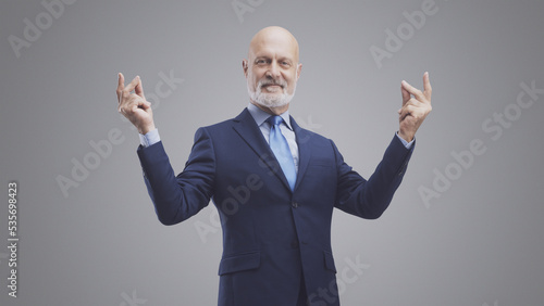 Smiling corporate businessman snapping fingers photo