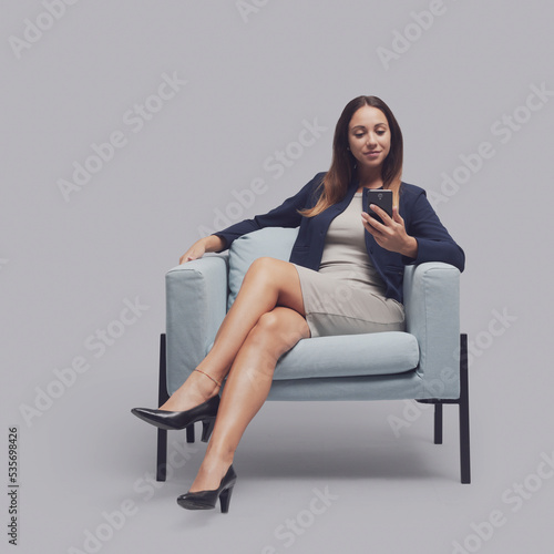 Confident businesswoman chatting with her phone