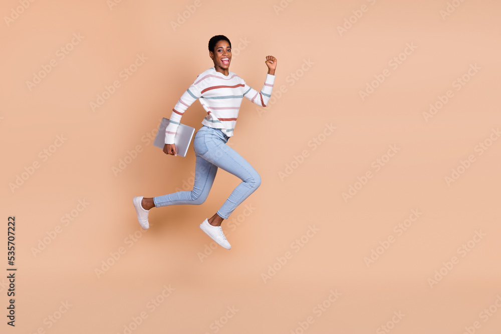Obraz premium Photo of charming sweet unisex person wear sweater running jumping holding device isolated beige color background