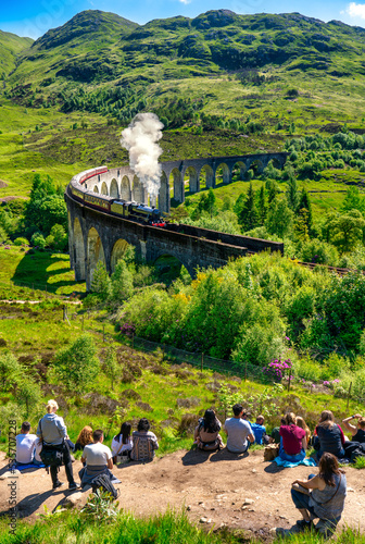 Vertical view of Glenfinnan Railway Viaduct seen by group of tourists in Scotland  photo