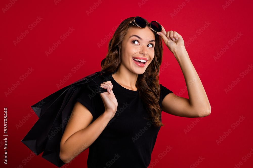 Profile side photo of young excited girl curious look empty space shopping bag boutique isolated over red color background Profile side photo of young excited girl curious look empty space shopping bag boutique isolated over red color background