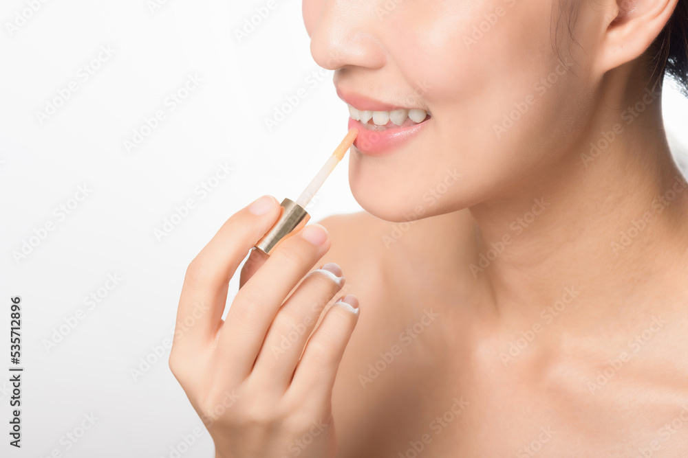 Portrait young asian woman looking mirror applying makeup lipstick at room