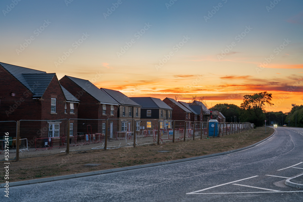 Obraz premium Row of new build houses under construction with sunset sky 