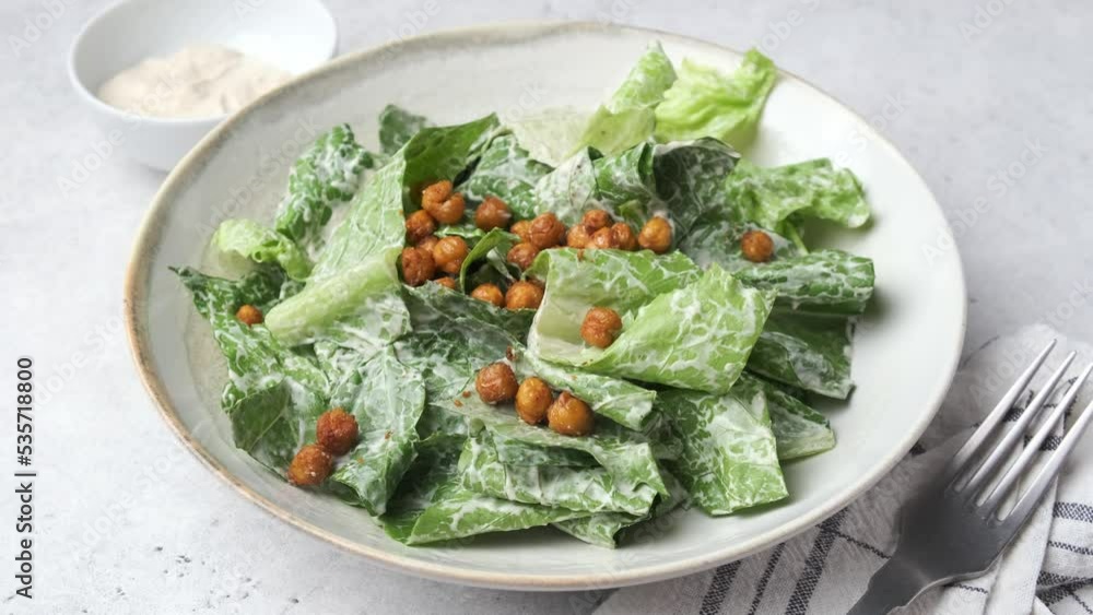 Vegan caesar salad with fried spicy chickpeas in a gray bowl. Vegan caesar salad with fried spicy chickpeas in a gray bowl.