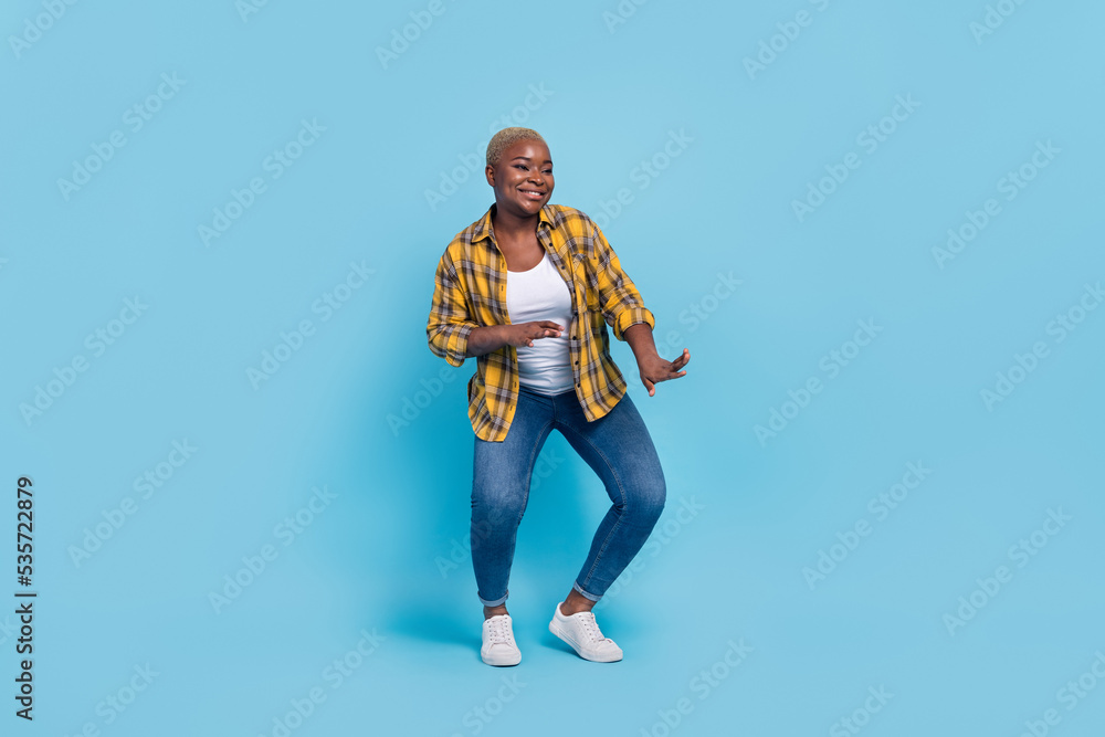 Full length photo of dreamy charming lady wear checkered shirt smiling dancing isolated blue color background Full length photo of dreamy charming lady wear checkered shirt smiling dancing isolated blue color background