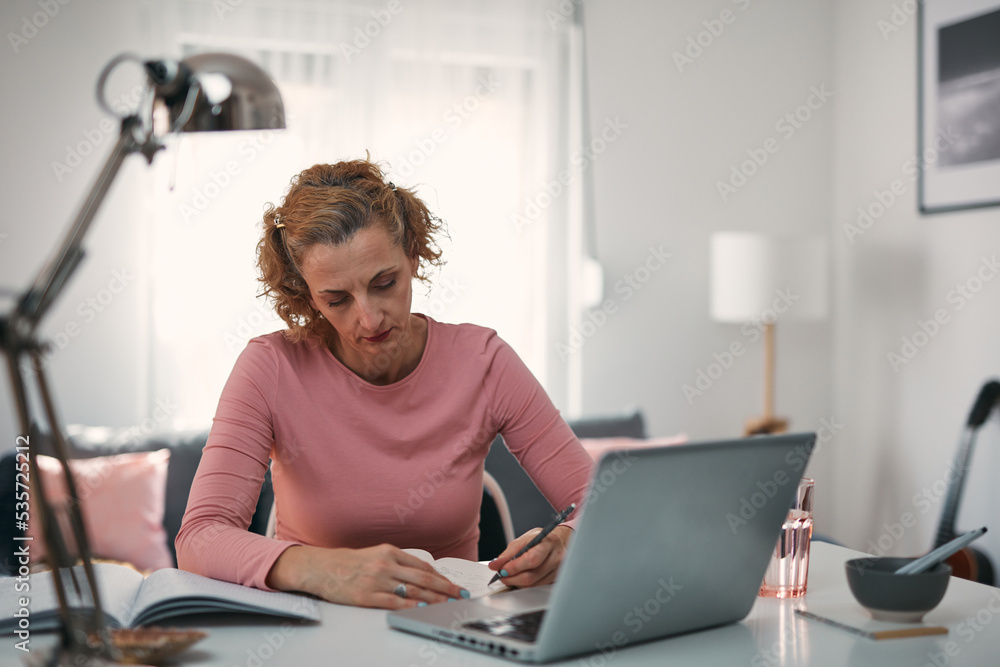 Woman in 40s working from living room at home.