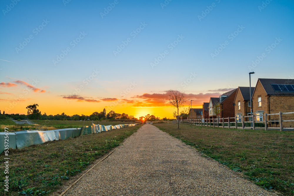Fototapeta premium Empty walkway path at sunset near new build housing area in southern England