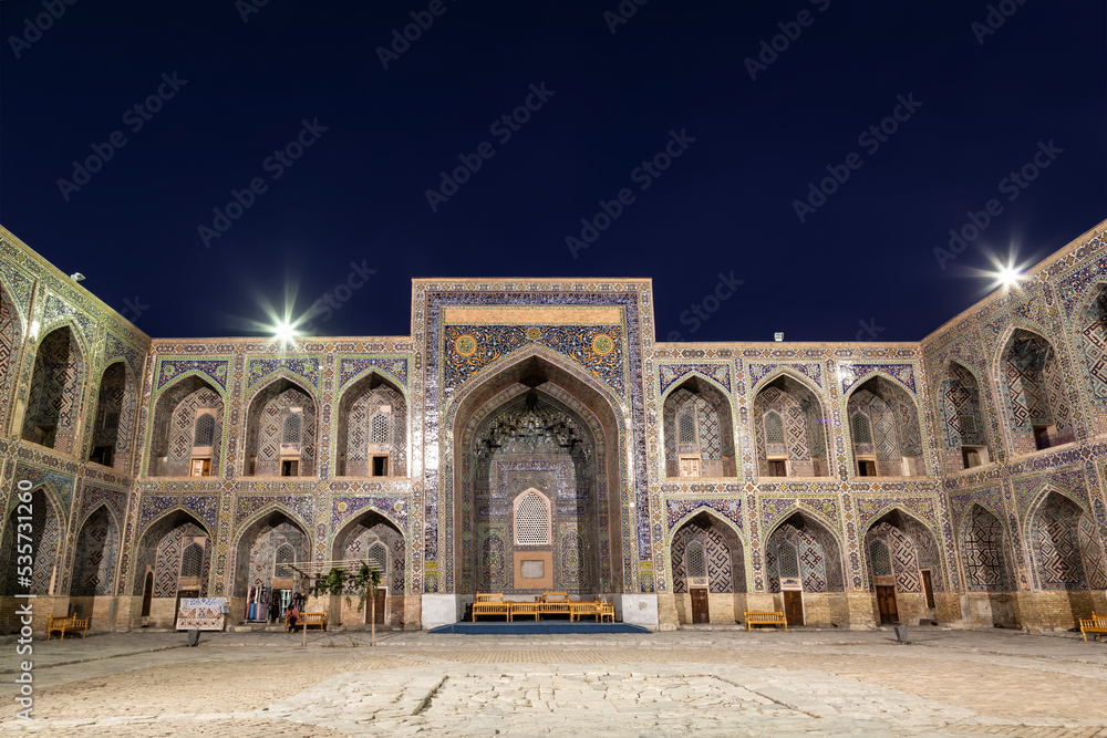 The courtyard of the Sherdor Madrasah is illuminated at night. Registan Square in Samarkand, Uzbekistan