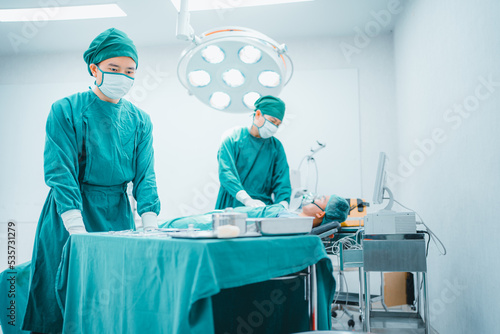 Low angle view, two Professional team confidence surgeon doctor performing surgery operation in theater operating room with medical instrument, tool, equipment. Healthcare, Hospital emergency concept