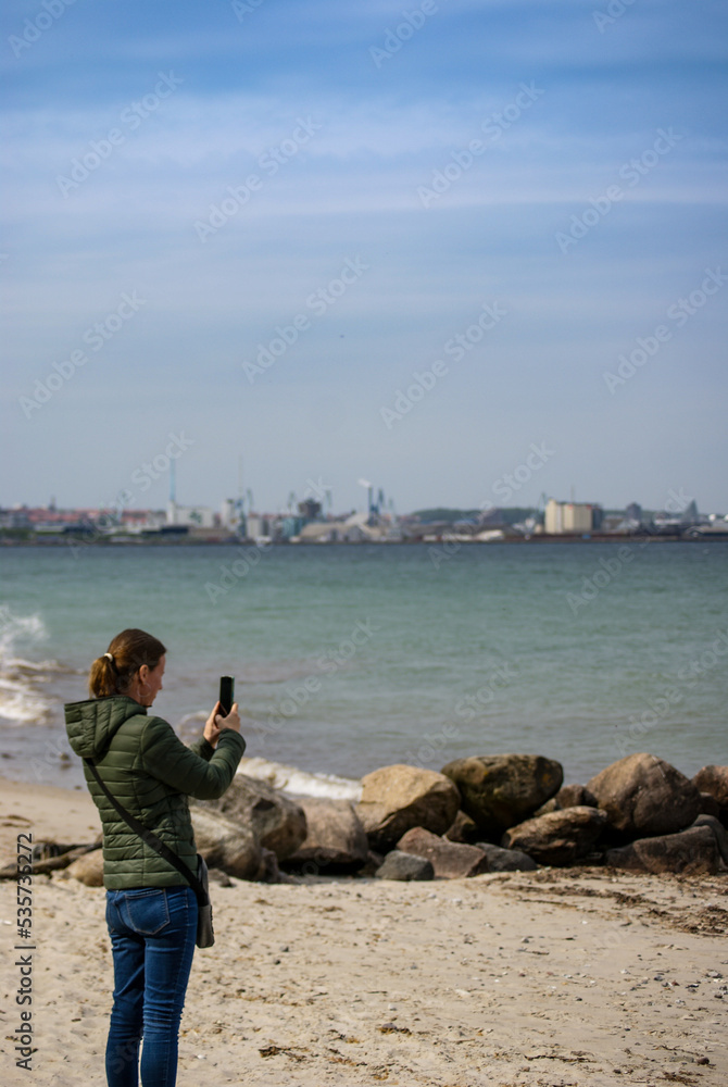 Woman taking photo at beach - Stock photo