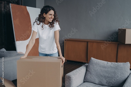 Quadro su tela Smiling woman with box preparing for house renovation or relocation, dreaming ab