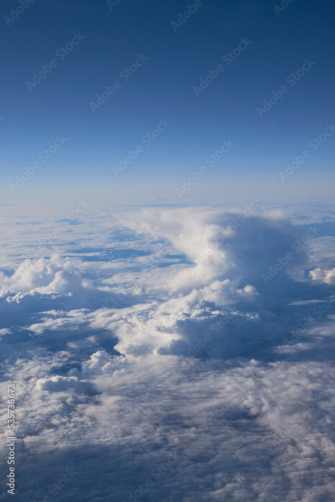 A view from above over clouds taken from an airplane A view from above over clouds taken from an airplane