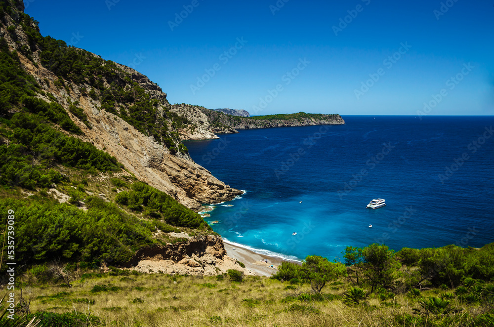 Beautiful scenery of a bay on Mallorca with pure blue water and a yacht.