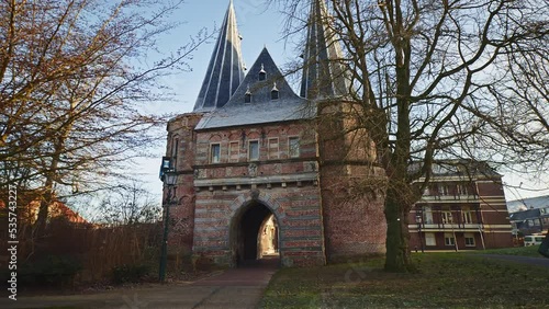 POV walking footage of an empty street in Kampen, the Netherlands, leading to an old city gate. photo