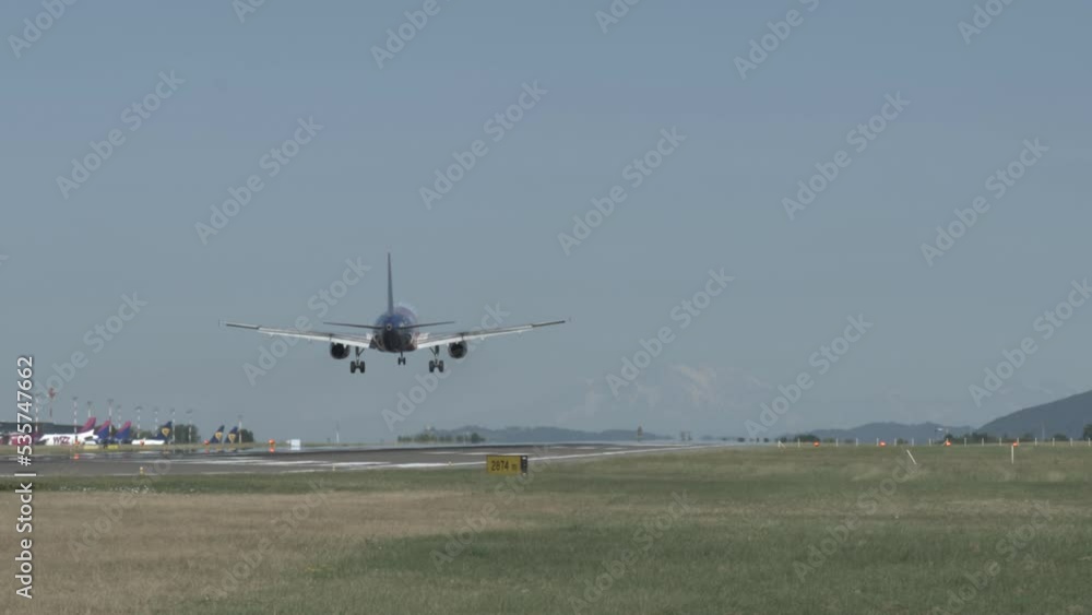 A passenger plane landing at Milan airport on a cloudy day A passenger plane landing at Milan airport on a cloudy day