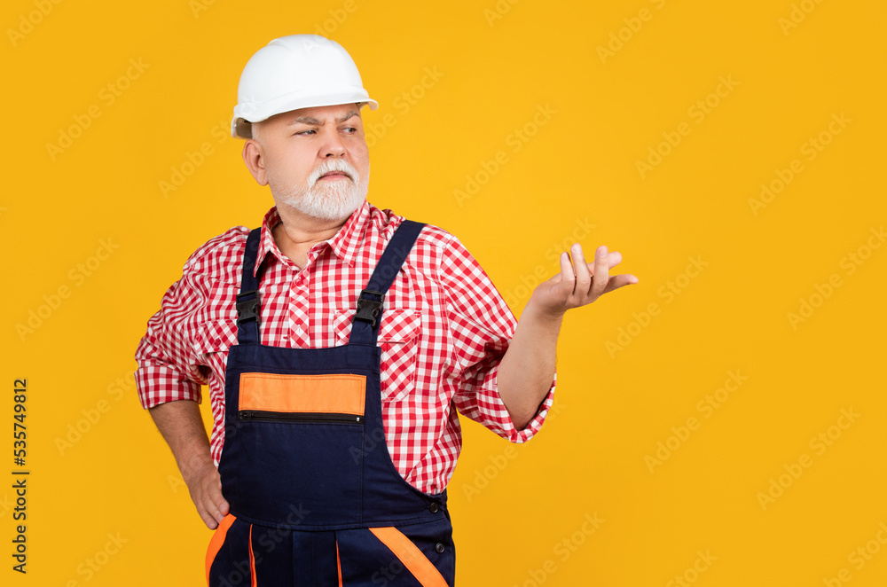 senior man builder in helmet on yellow background senior man builder in helmet on yellow background