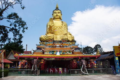 Big buddha statue of Wat Maniwong for thai people travel visit and respect praying blessing holy worship mystical in Mani Wong temple at Nakhonnayok city on September 6, 2022 in Nakhon Nayok Thailand © tuayai