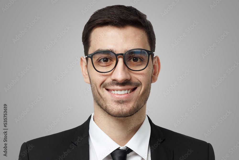 Confident smiling friendly businessman in glasses wearing black formal suit, white shirt and tie