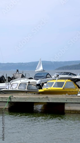 Vertical footage of boats moored at a pier on a sunny day photo