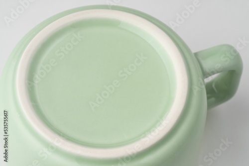 Fotografie Closeup shot of the underside of a pastel green tea cup