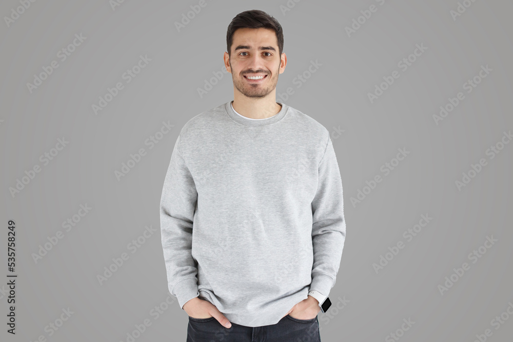 Young man in oversized sweatshirt, isolated on gray Young man in oversized sweatshirt, isolated on gray