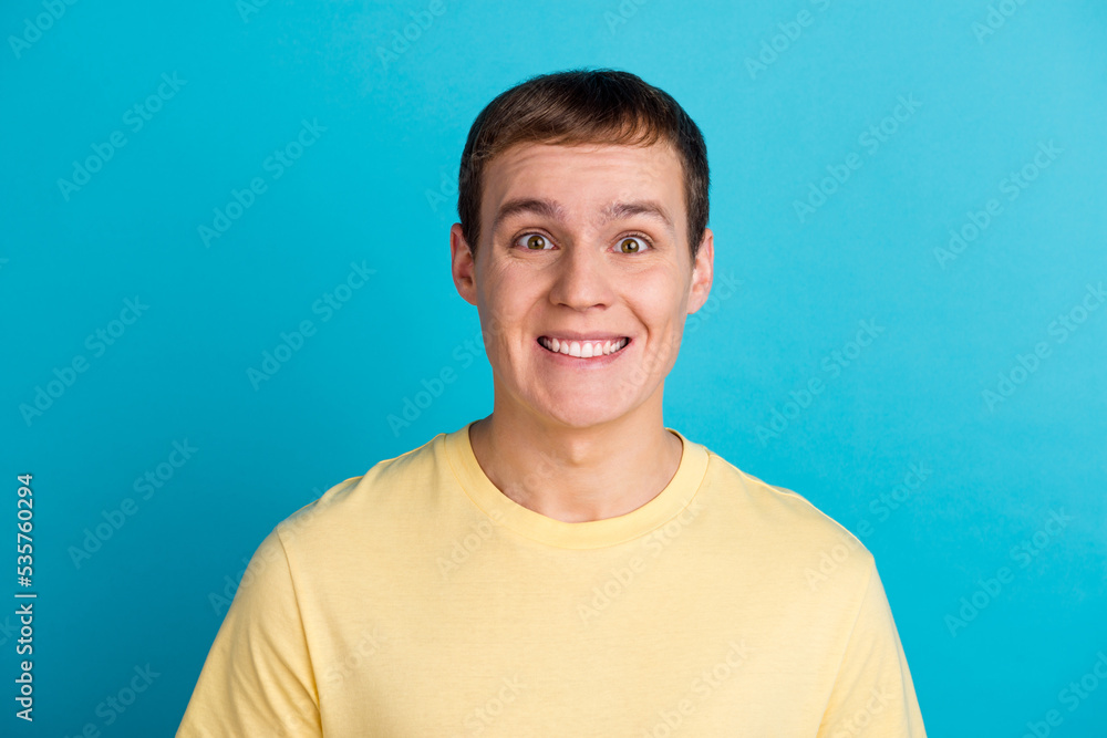 Young energetic man looking in camera beaming smiling isolated on blue color background Young energetic man looking in camera beaming smiling isolated on blue color background