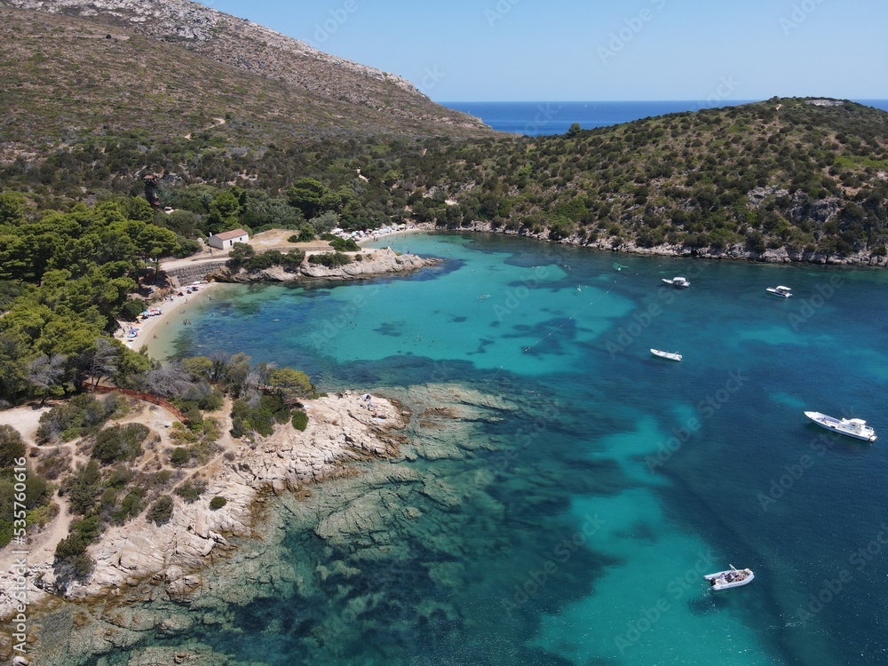 Aerial view of Cala Moresca and Figarolo Island in Golfo Aranci, north Sardinia. Birds eye from above of yacht, boats, crystalline and turquoise water. Tavolara Island in the background, Sardegna. Aerial view of Cala Moresca and Figarolo Island in Golfo Aranci, north Sardinia. Birds eye from above of yacht, boats, crystalline and turquoise water. Tavolara Island in the background, Sardegna.