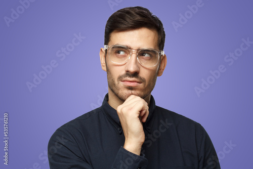 Pensive thoughtful business man on purple background