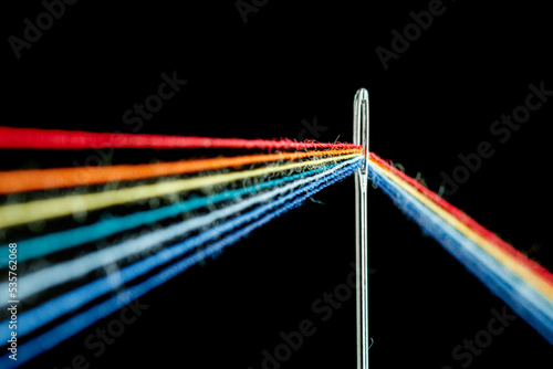 Φωτογραφία multi-colored threads for sewing in the form of a rainbow pass through an antiqu