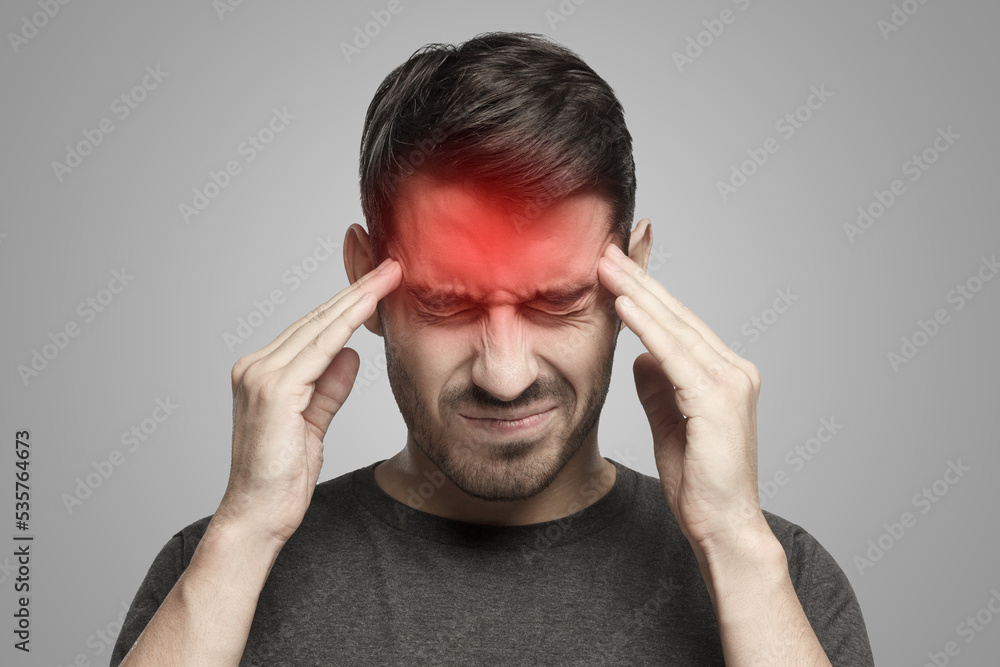 Portrait of man suffering from severe headache, pressing fingers to temples with closed eyes Portrait of man suffering from severe headache, pressing fingers to temples with closed eyes