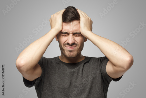 Canvas Print Man showing how much head hurts, experiencing pain, looking miserable and exhaus