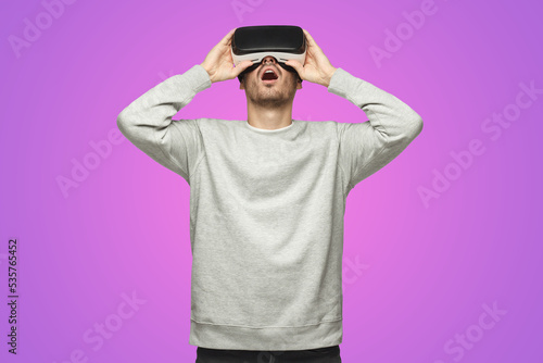 Astonished man experiencing virtual reality using VR headset for entertaining