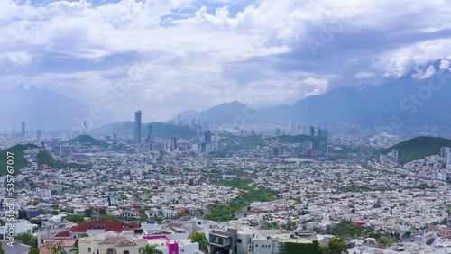 Monterrey Nuevo León in México, the city of mountains. Drone view of cityscape with business buildings, architecture, Cerro de La Silla, Obispado mountain with flag of mexico and beautiful blue sky. photo