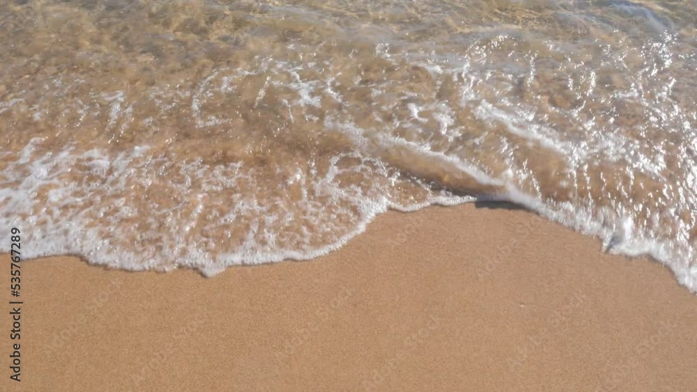 Sea waves with white foam wash the golden sand, close up. Tropical nature background Sea waves with white foam wash the golden sand, close up. Tropical nature background