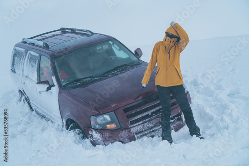 Obraz na płótnie Woman suffered an accident in the snow with her car in the middle of a freezing storm. w salonie
