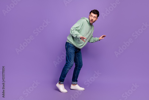 Fotografie Full length side photo of nervous funny man look empty space walk silent robbery