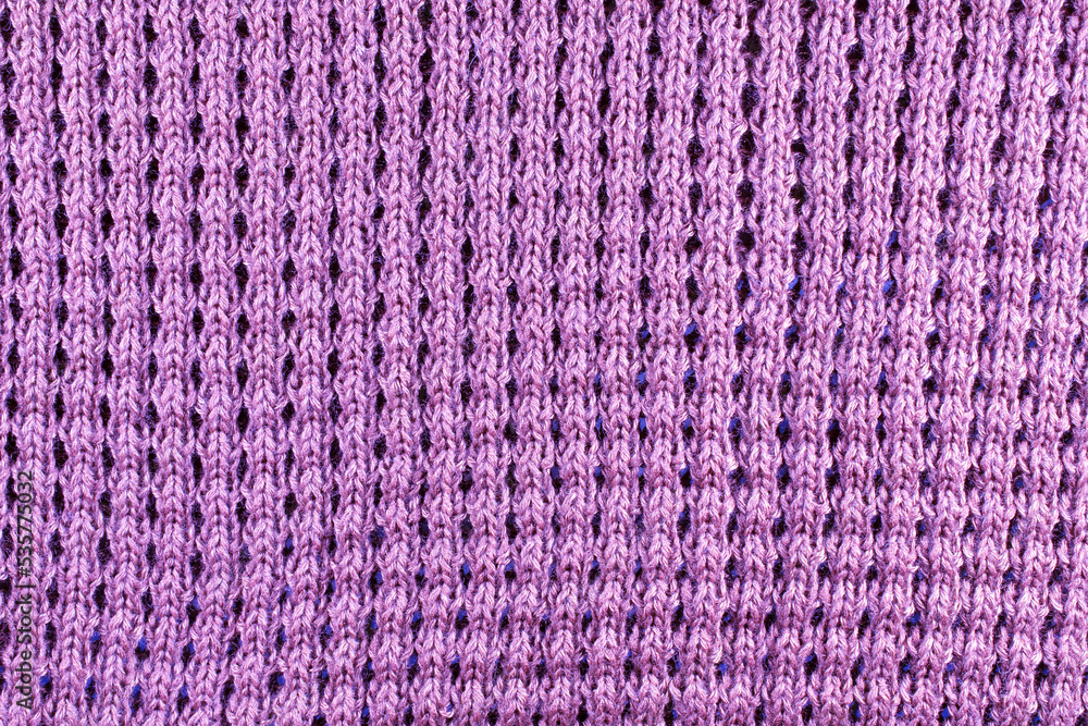 Violet wool knitted textured background close up. Handmade knitted fabric violet wool background texture.