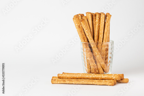 Classic crispy bread sticks grissini in glass. Traditional Italian pastry breadsticks on white background with copy space photo