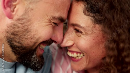 Happy young couple rubbing their nose together and touching faces. Close up of intimate, married and loving man and woman with faces, forehead and noses together and holding hands and in love photo