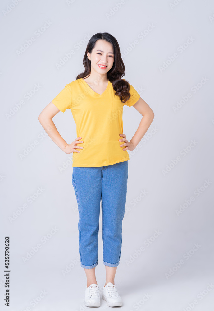 Full length photo of young Asian woman standing on white background