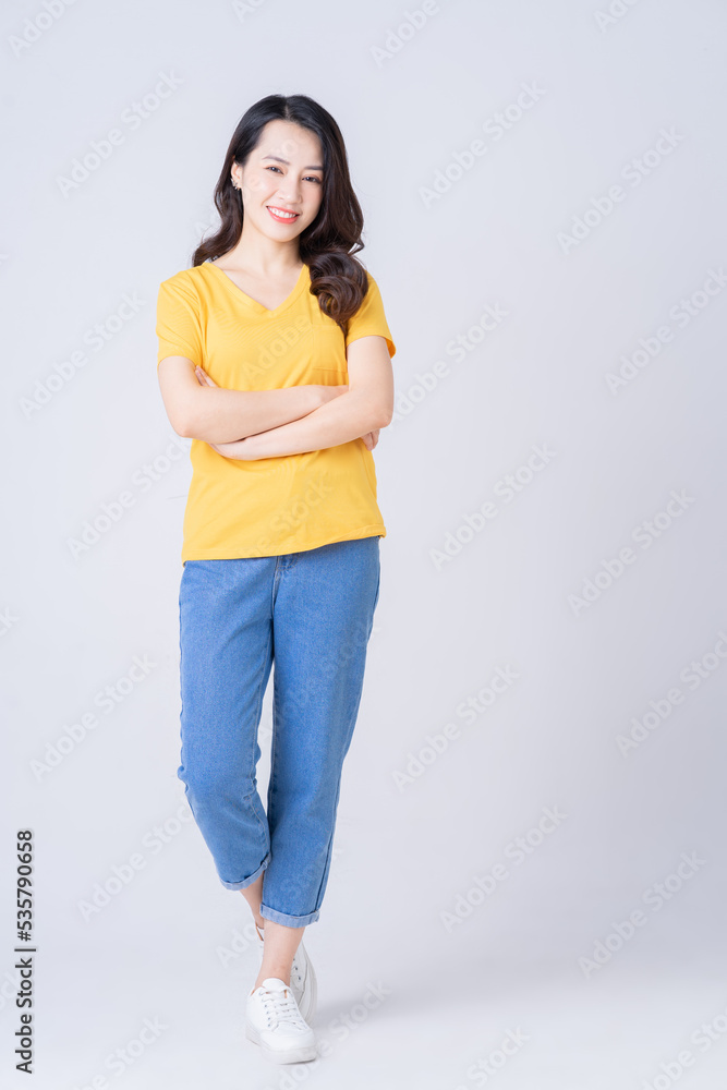 Full length photo of young Asian woman standing on white background Full length photo of young Asian woman standing on white background