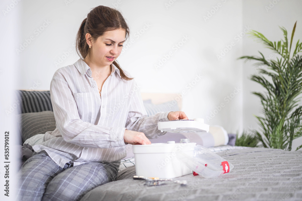 Female housewife checking medicines at domestic first aid kit neatly placing storage organization Female housewife checking medicines at domestic first aid kit neatly placing storage organization