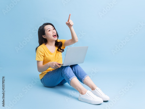 Image of young Asian woman sitting and using laptop © Timeimage