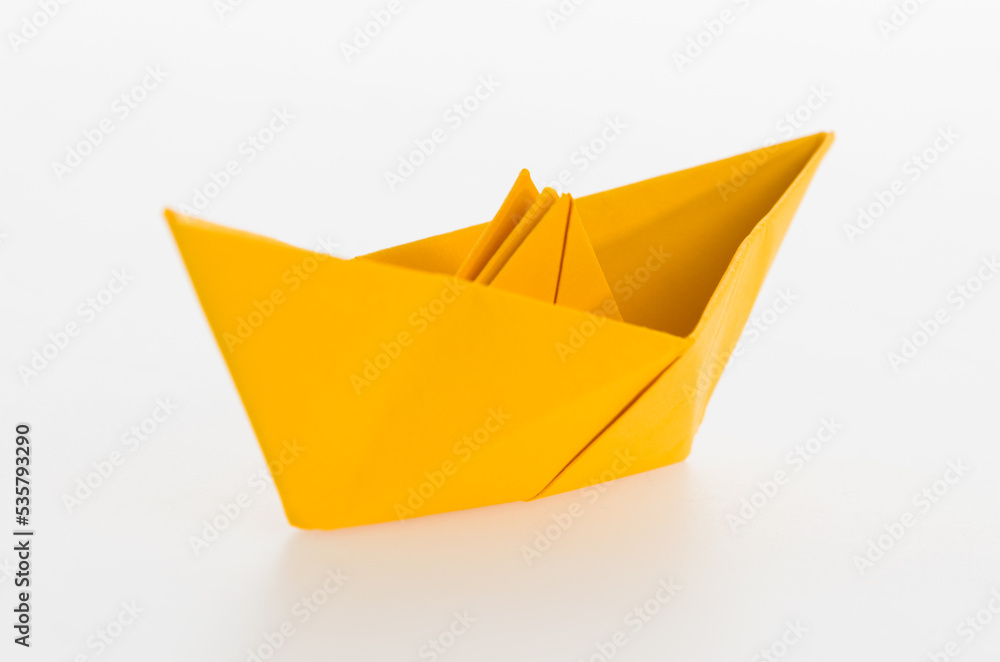 Naklejka premium Yellow origami boat on white background