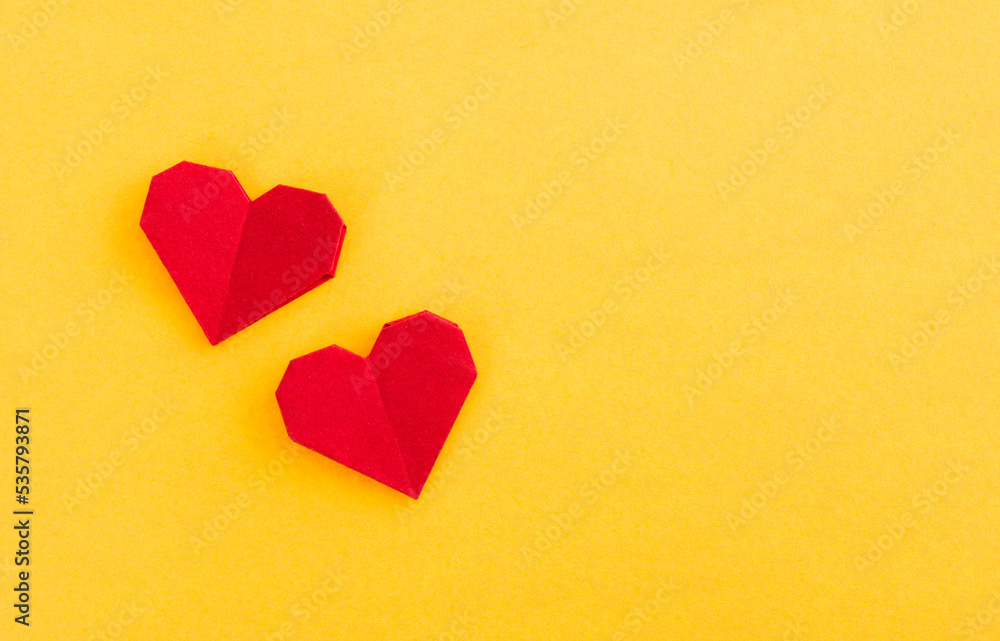 Red origami hearts on yellow background Red origami hearts on yellow background