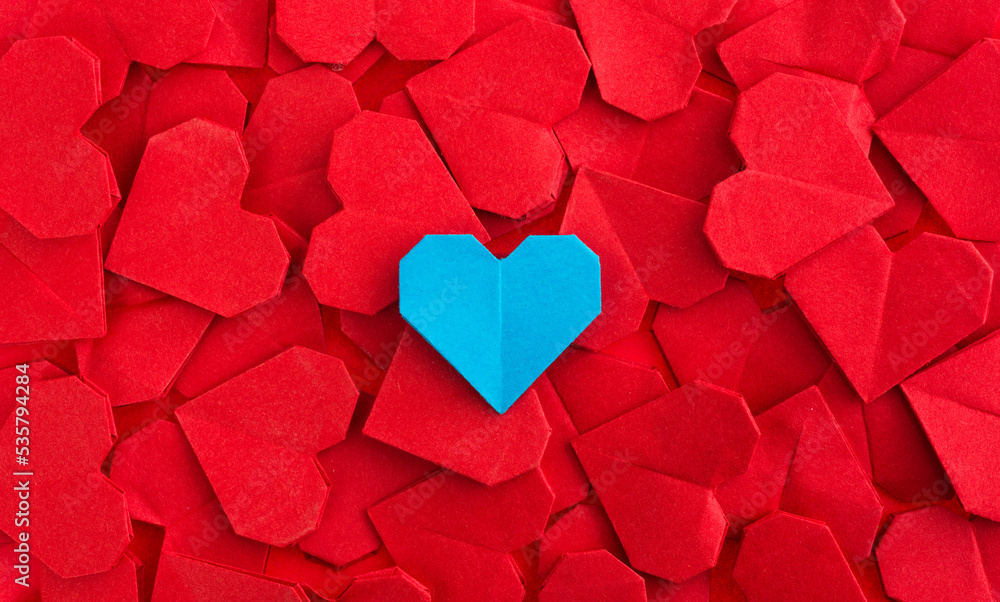 Obraz premium Blue origami heart on red origami hearts
