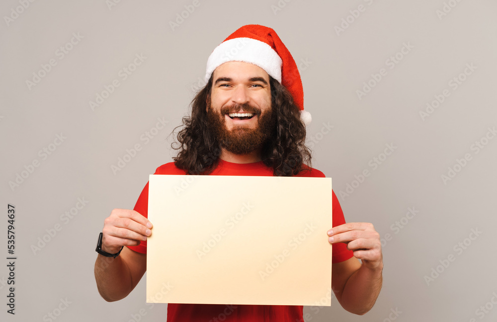 Smiling bearded man is holding a blank rectangular shape for copy space.