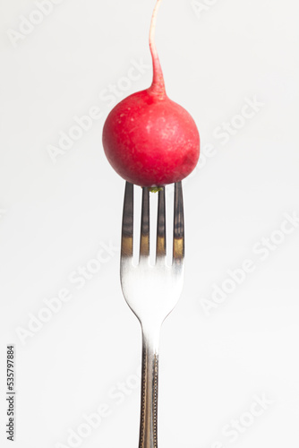Red radish on a fork isolated