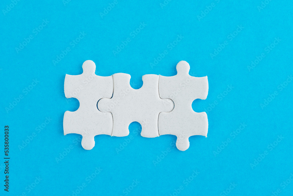 Fototapeta premium Three puzzle pieces on blue background